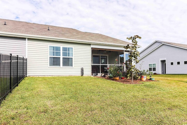 rear view of house featuring a lawn and ceiling fan