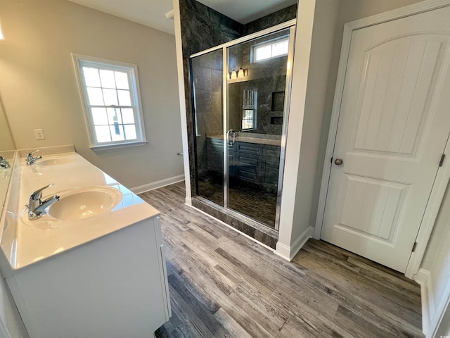 bathroom featuring hardwood / wood-style flooring, a wealth of natural light, and a shower with shower door