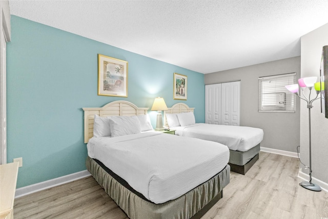 bedroom featuring light wood-type flooring, a textured ceiling, and a closet