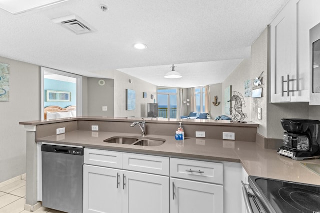 kitchen featuring dishwasher, sink, stove, a textured ceiling, and white cabinets