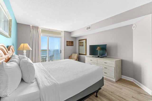 2701 S Ocean Blvd Unit 1817, North Myrtle Beach, SC 29582 - bedroom featuring access to exterior, light wood-type flooring, and a textured ceiling