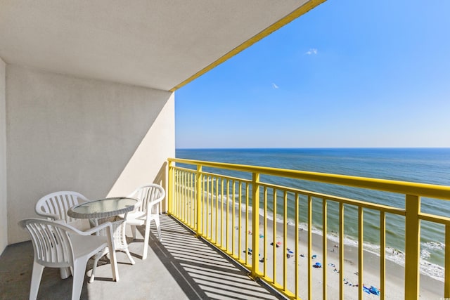 balcony featuring a view of the beach and a water view