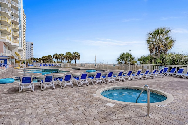 view of swimming pool with a hot tub