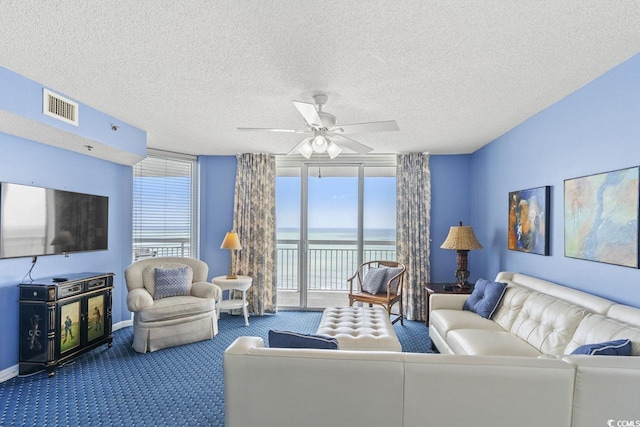 living room with visible vents, a textured ceiling, a water view, a ceiling fan, and carpet