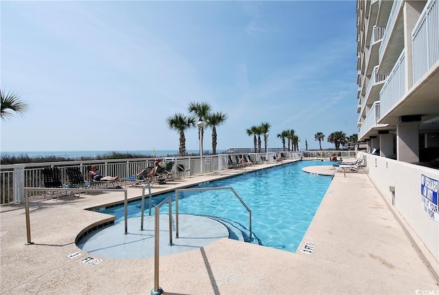 community pool with a patio and fence