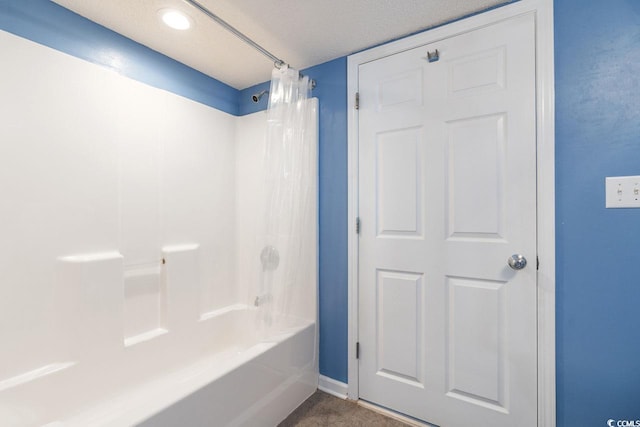 bathroom featuring shower / bath combo with shower curtain and a textured ceiling