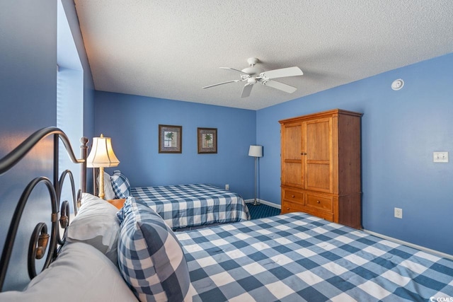 carpeted bedroom with ceiling fan and a textured ceiling