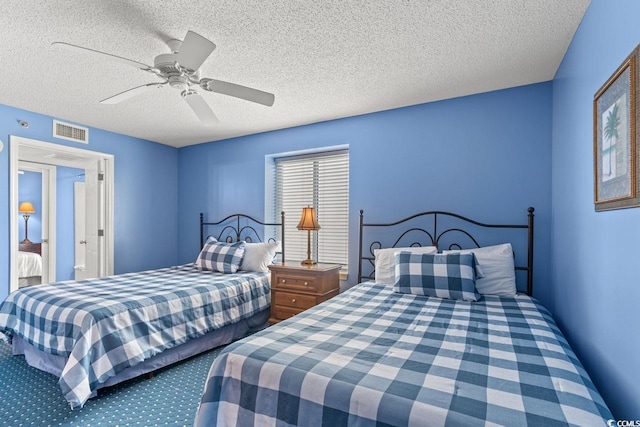 carpeted bedroom featuring visible vents, a ceiling fan, and a textured ceiling