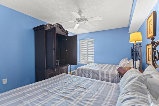 bedroom with ceiling fan and a textured ceiling