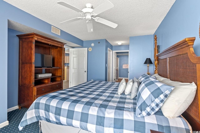 carpeted bedroom featuring visible vents, a textured ceiling, ceiling fan, and baseboards