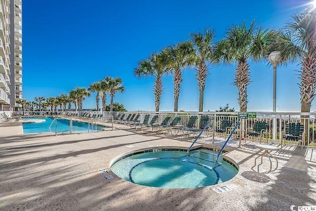 view of swimming pool with a hot tub and a patio area