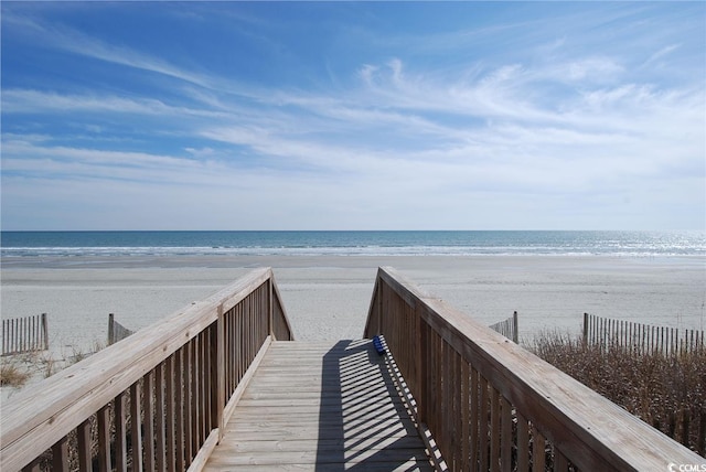 surrounding community with a water view and a view of the beach