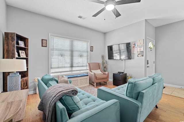 living room with hardwood / wood-style floors, ceiling fan, and a textured ceiling