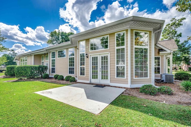 rear view of house with a yard, a patio area, and central AC unit