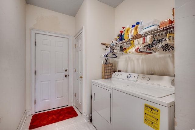 laundry area with light tile patterned flooring and washer and clothes dryer