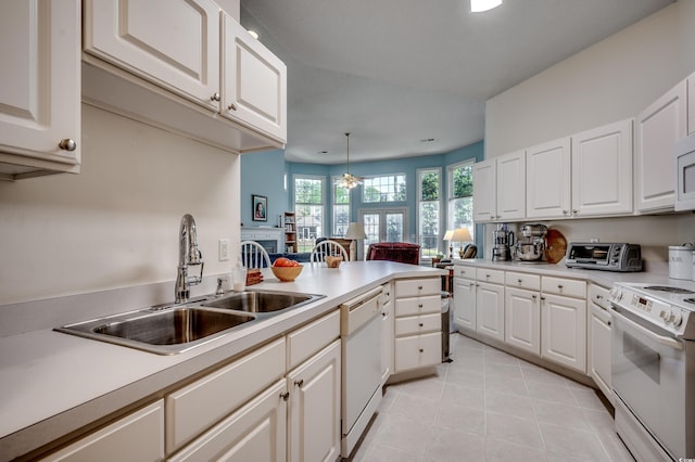 kitchen featuring sink, white cabinets, decorative light fixtures, and white appliances