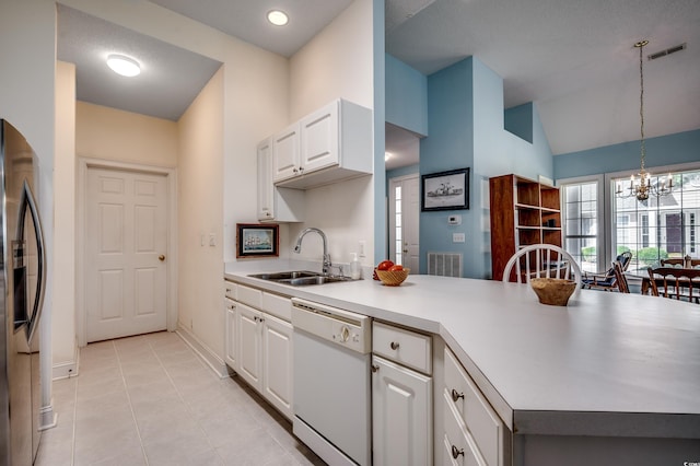 kitchen with stainless steel fridge, white cabinets, white dishwasher, pendant lighting, and sink