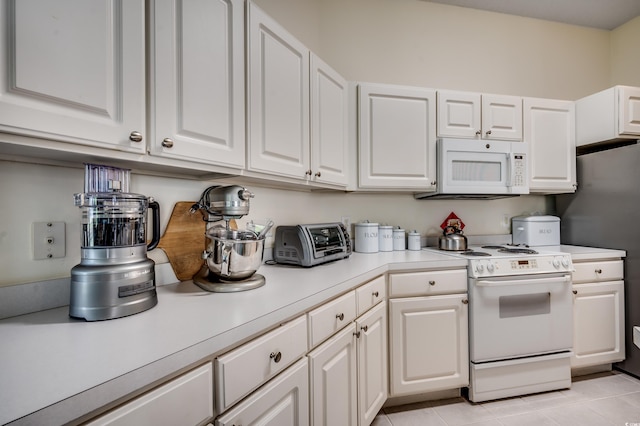 kitchen featuring white appliances, white cabinetry, and light tile patterned flooring