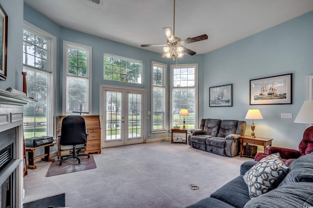 carpeted living room featuring french doors and ceiling fan