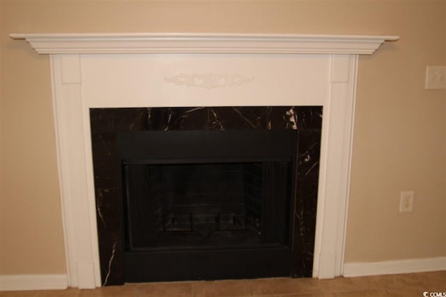 room details with a premium fireplace and tile patterned floors