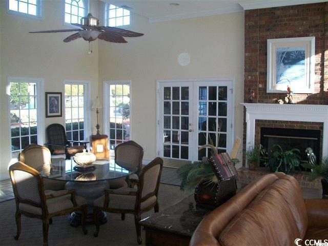 interior space with crown molding, ceiling fan, a fireplace, and a wealth of natural light