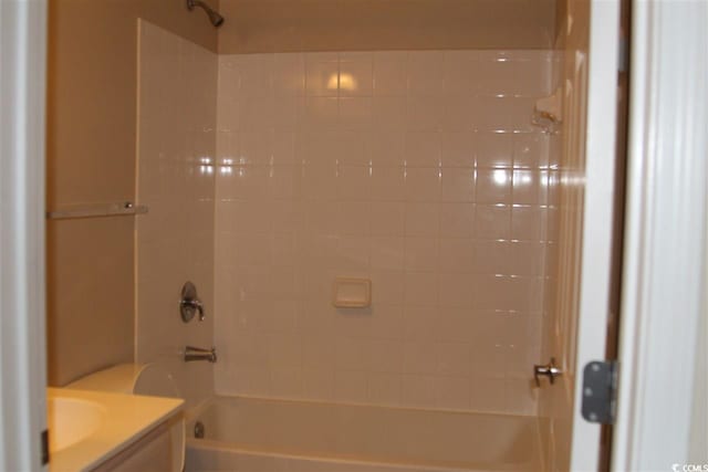 full bathroom featuring vanity, tiled shower / bath combo, and toilet