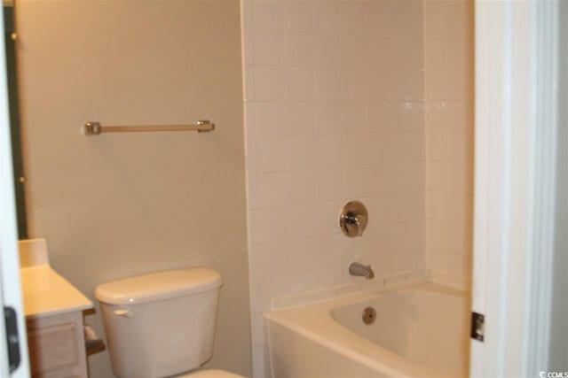 full bathroom with tiled shower / bath, vanity, and toilet