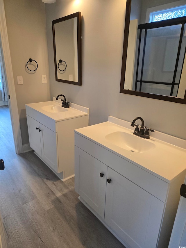 bathroom with vanity, hardwood / wood-style flooring, and a shower with door