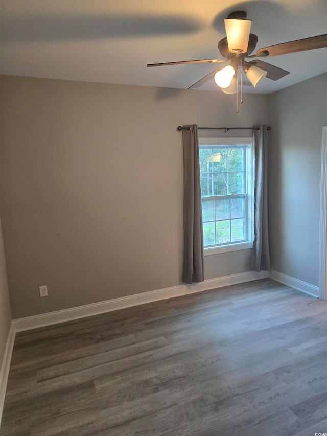 empty room with ceiling fan and dark hardwood / wood-style flooring