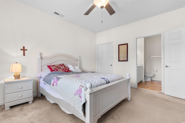 carpeted bedroom with connected bathroom and ceiling fan