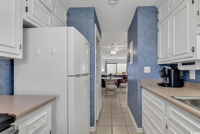 kitchen featuring ceiling fan, light tile patterned flooring, and white cabinets