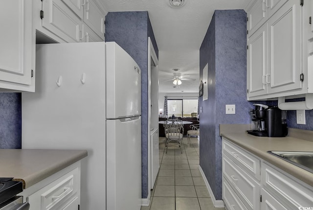 9621 Shore Dr Unit G219, Myrtle Beach, SC 29572 - kitchen with freestanding refrigerator, light tile patterned flooring, ceiling fan, and white cabinetry