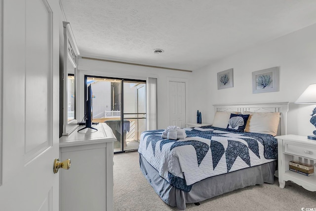 carpeted bedroom with a textured ceiling and access to outside