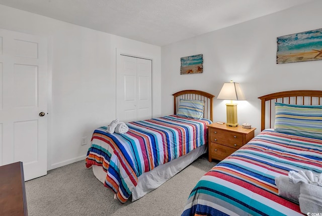 bedroom featuring a textured ceiling, light colored carpet, and a closet