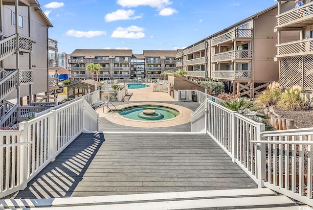 view of community featuring a swimming pool with hot tub