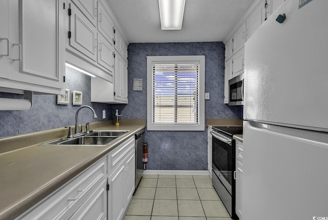 9621 Shore Dr Unit G219, Myrtle Beach, SC 29572 - kitchen with stainless steel appliances, white cabinetry, light tile patterned floors, a textured ceiling, and light countertops