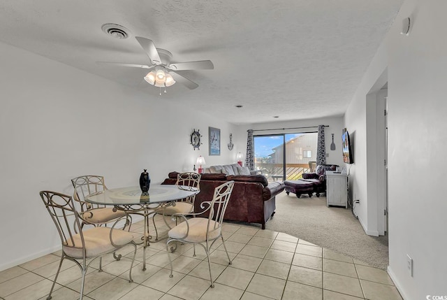 dining space with light carpet, a textured ceiling, and ceiling fan