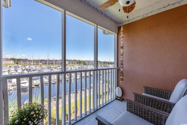 balcony featuring ceiling fan and a water view