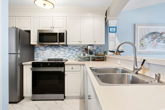 kitchen featuring crown molding, appliances with stainless steel finishes, decorative backsplash, white cabinets, and sink