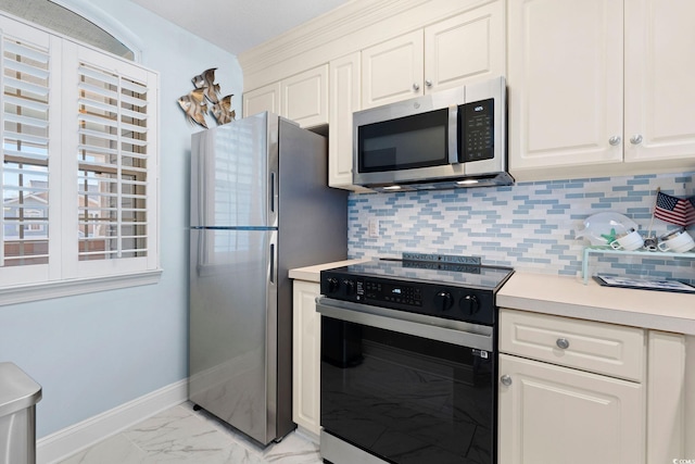 kitchen with white cabinets, tasteful backsplash, and stainless steel appliances