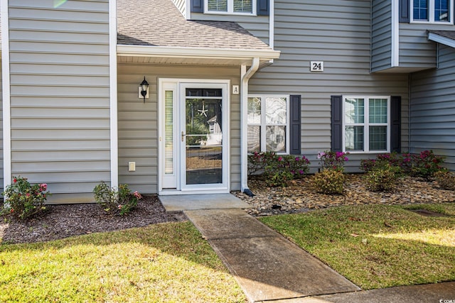 property entrance with a lawn