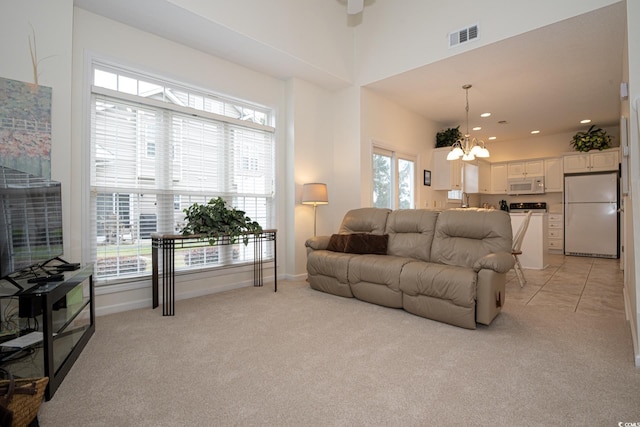 carpeted living room with a towering ceiling and an inviting chandelier