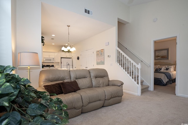 carpeted living room with a chandelier