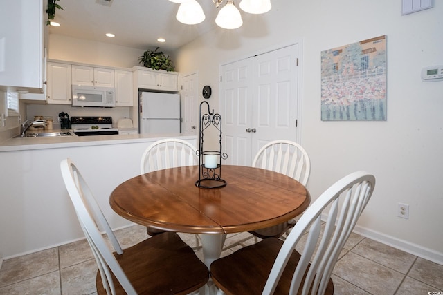 dining space featuring sink and light tile patterned floors