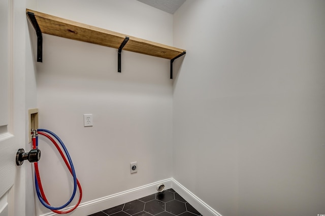 laundry area featuring hookup for an electric dryer, dark tile patterned floors, and washer hookup