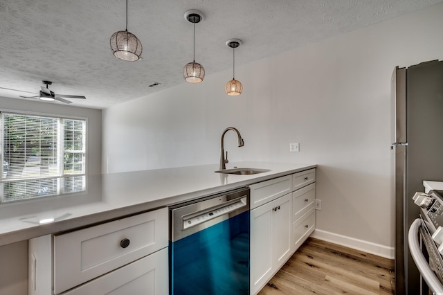 4641 Lightkeepers Way Unit 3-D, Little River, SC 29566 - kitchen featuring appliances with stainless steel finishes, a sink, white cabinetry, light wood finished floors, and a textured ceiling
