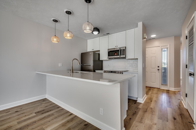 4641 Lightkeepers Way Unit 3-D, Little River, SC 29566 - kitchen featuring stainless steel microwave, freestanding refrigerator, a sink, a peninsula, and backsplash