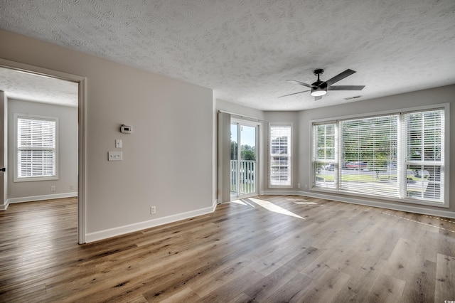 unfurnished room with ceiling fan, hardwood / wood-style flooring, and a textured ceiling