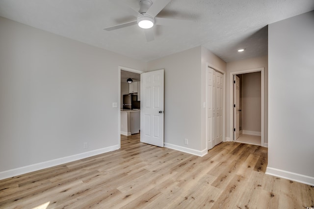 empty room featuring ceiling fan, a textured ceiling, and light wood-type flooring