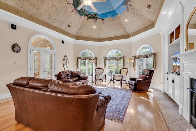 living room featuring high vaulted ceiling, ornamental molding, ceiling fan, light wood-type flooring, and french doors